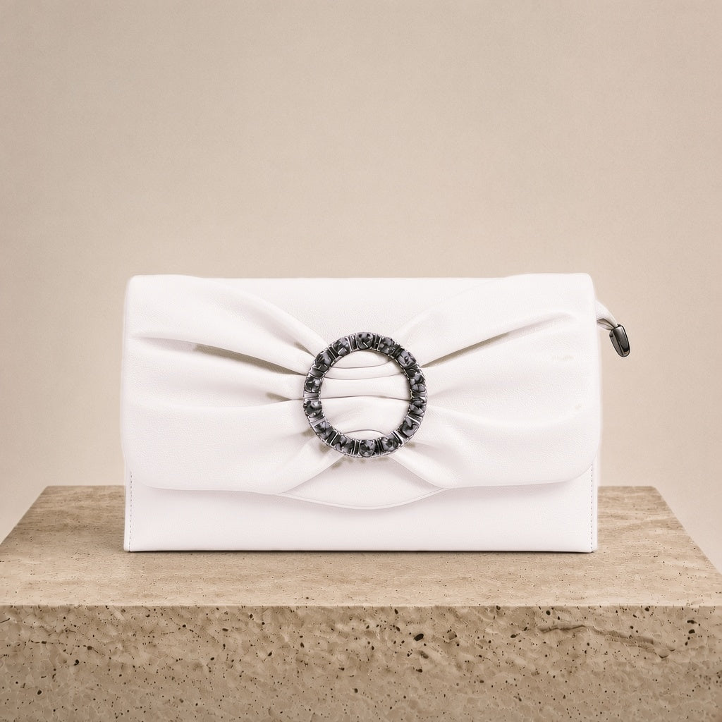 Pochette froncée en cuir SAKIWE blanc cassé posée sur un socle en pierre