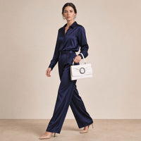 Pochette froncée en cuir SAKIWE blanc cassé portée au poignet avec la dragonne