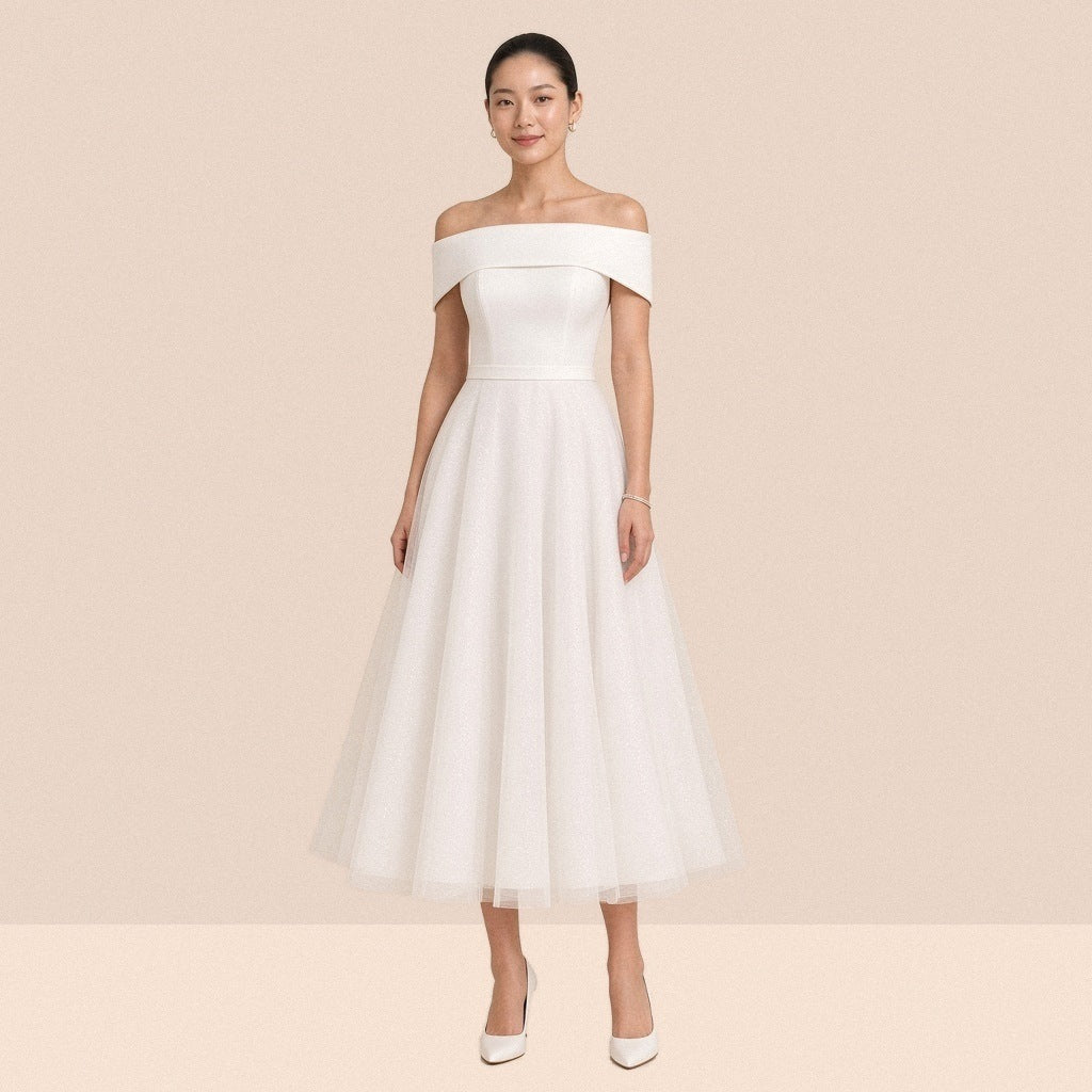Robe blanche mi-longue à épaules dénudées et revers satiné – vue de face, portée par une mannequin.