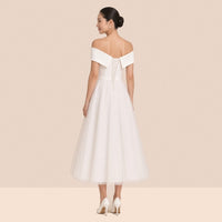 Robe blanche mi-longue – vue de dos : revers en V à pointes repliées et laçage croisé au dos.
