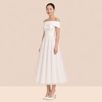 Robe blanche mi-longue à épaules dénudées et revers satiné – vue de trois quarts.