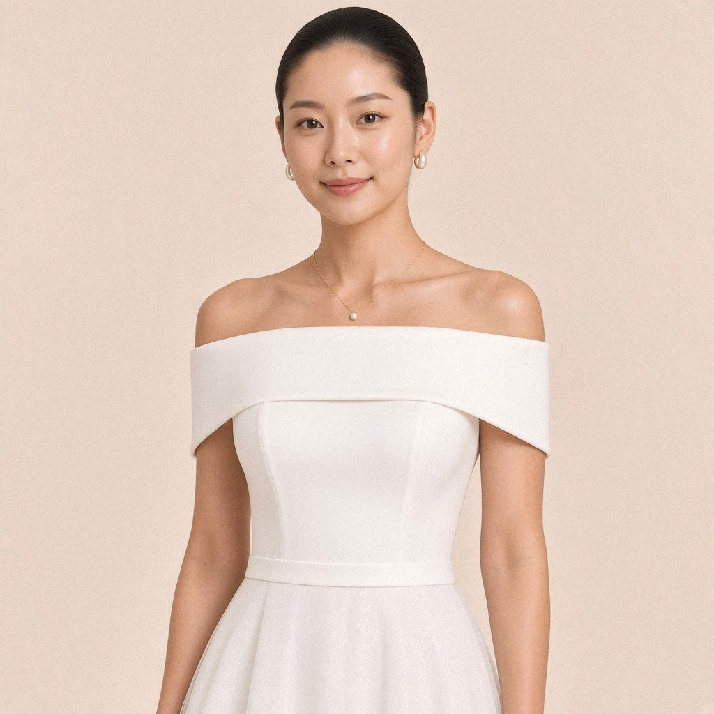 Robe blanche – détail du revers satiné à épaules dénudées et du corsage ajusté à découpes.
