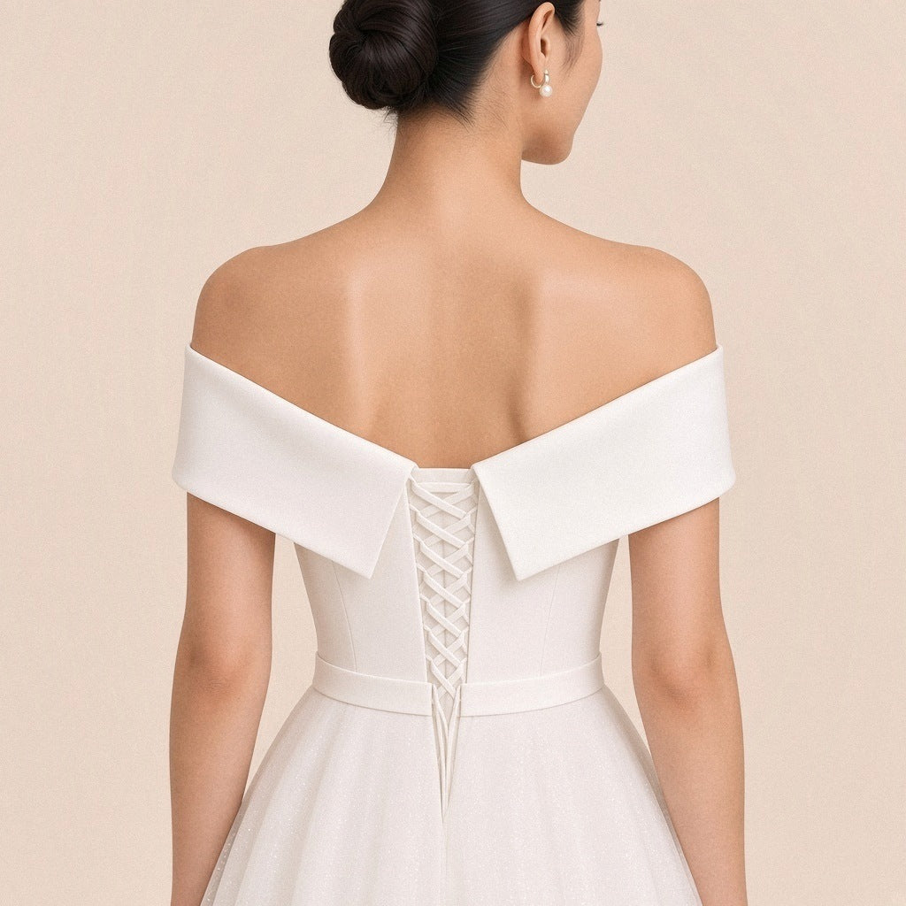 Robe blanche – détail du dos : revers en V et laçage croisé jusqu’à la taille.