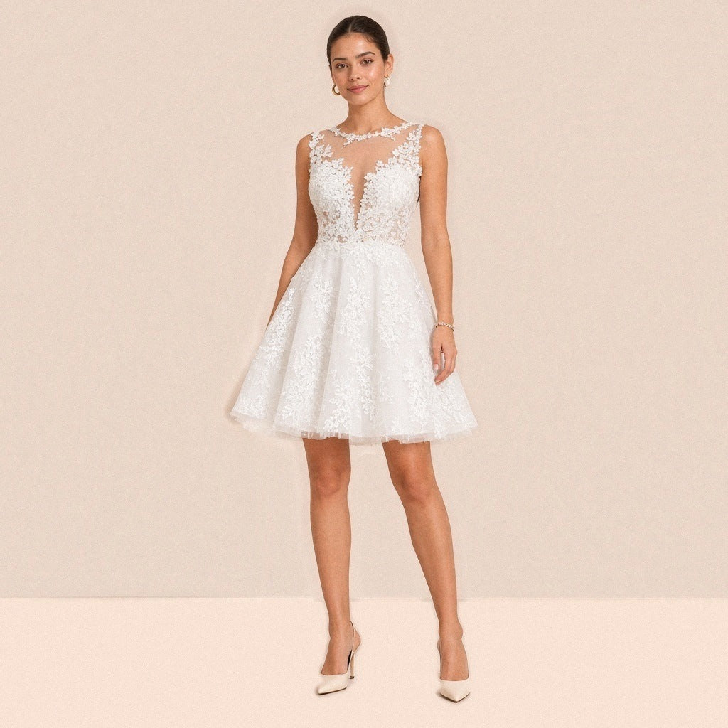 Robe courte en dentelle blanche portée de face, encolure illusion et jupe en tulle évasée