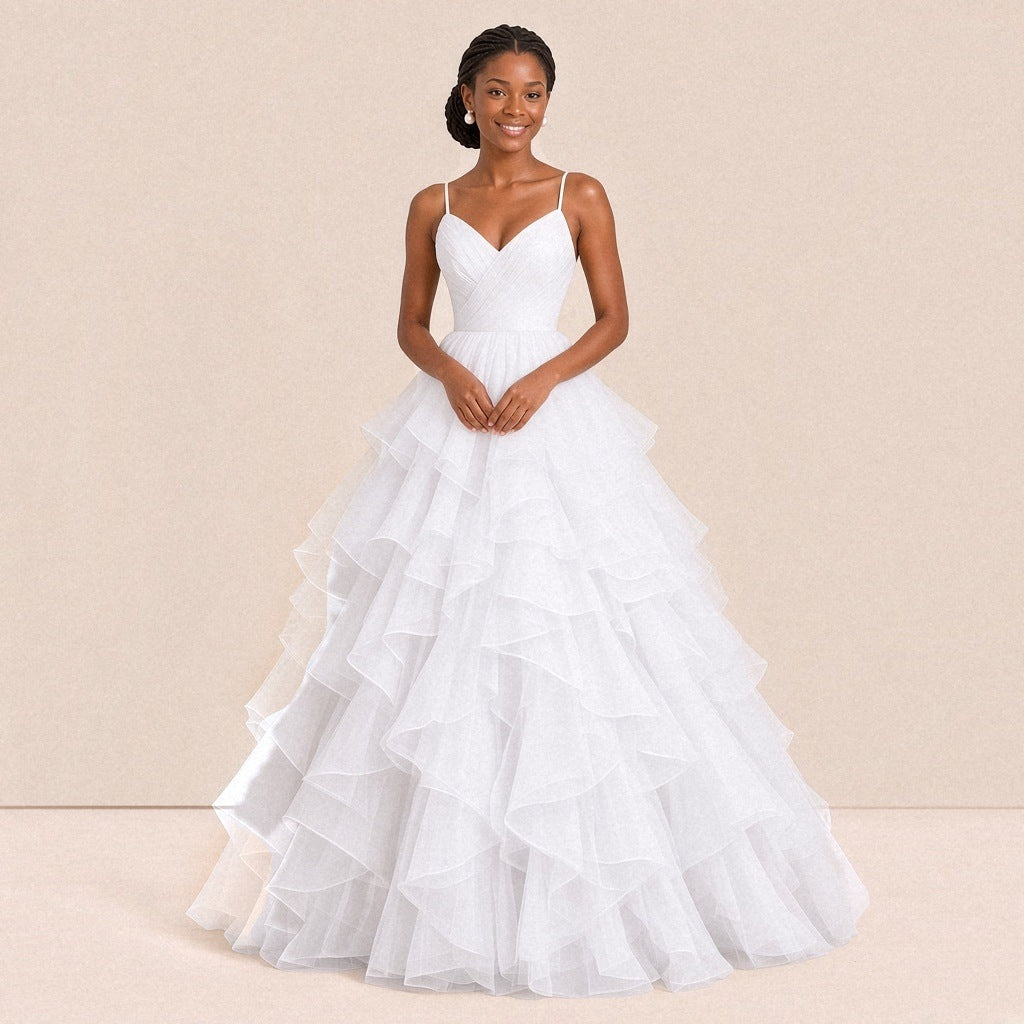 Robe de bal longue blanche en tulle à volants, portée de face, bretelles fines et buste drapé en V