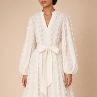 Robe fluide en voile SAKIWE blanc cassé portée, en gros plan sur le col V, les volants et la ceinture