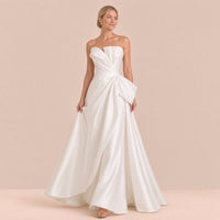 Femme marchant dans la robe de mariée bustier en satin, jupe trapèze jusqu’au sol