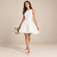 Robe de mariée blanche courte portée en mouvement, jupe plissée évasée