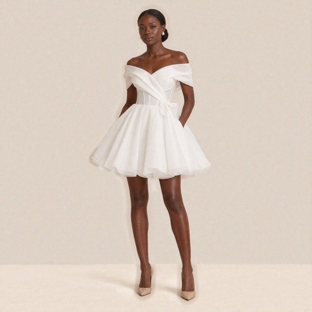 Femme portant la robe de mariée courte bouffante épaules dénudées, vue de face