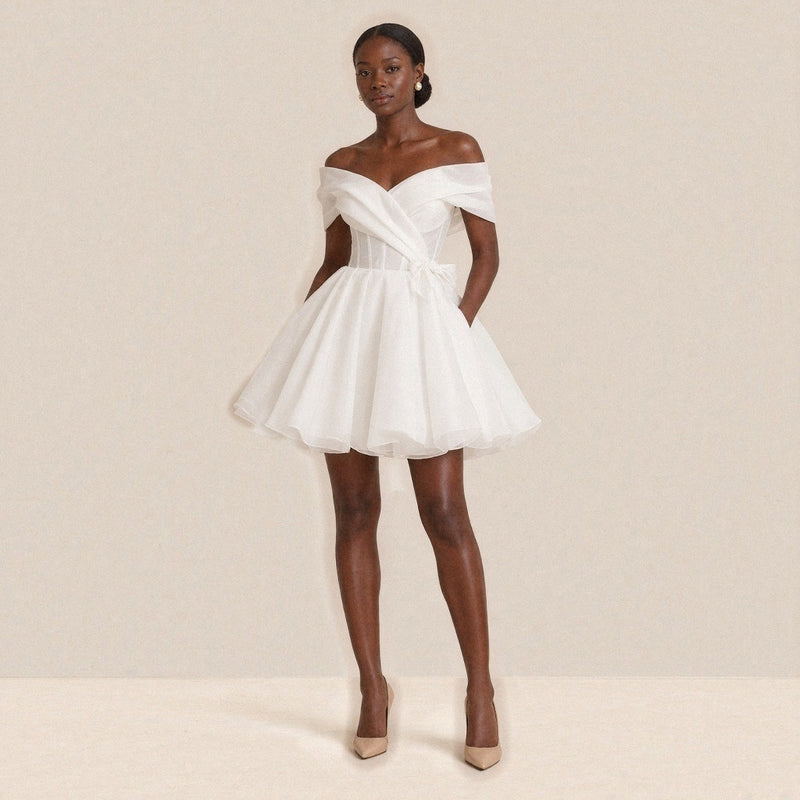 Femme portant la robe de mariée courte bouffante épaules dénudées, vue de face