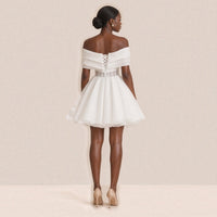 Femme de dos dans la robe de mariée courte : dos à lacets et taille corset transparente