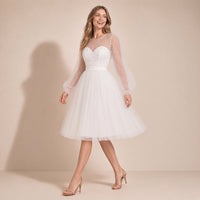 Femme en mouvement dans la robe de mariée courte ivoire, jupe en tulle au genou