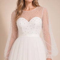 Robe de mariée ivoire portée, détail du col rond transparent, du bustier en cœur perlé et de la ceinture satinée