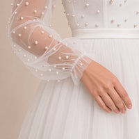 Robe de mariée ivoire portée, détail de la manche en tulle à perles resserrée au poignet