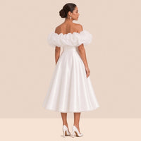 Robe de mariée blanche courte – vue de dos : volant en organza à épaules dénudées, jupe évasée sous le genou.