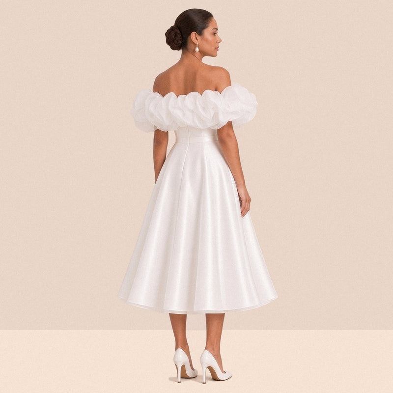 Robe de mariée blanche courte – vue de dos : volant en organza à épaules dénudées, jupe évasée sous le genou.