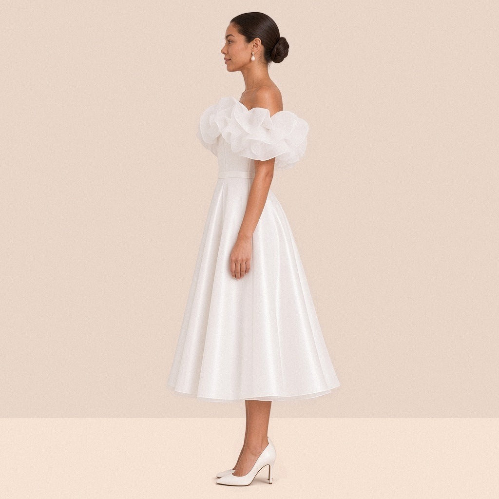 Robe de mariée blanche courte à volants – vue de profil, longueur sous le genou.