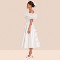 Robe de mariée blanche courte à volants – vue de profil, longueur sous le genou.