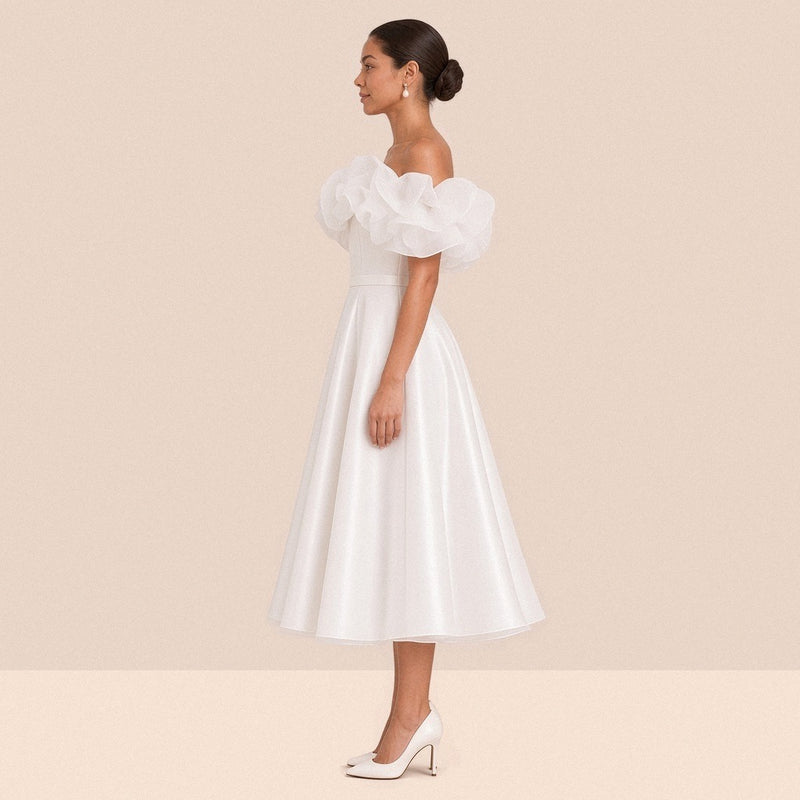 Robe de mariée blanche courte à volants – vue de profil, longueur sous le genou.