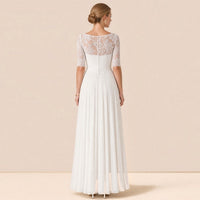 Robe de mariée en dentelle vue de dos : empiècement transparent et rangée de petits boutons