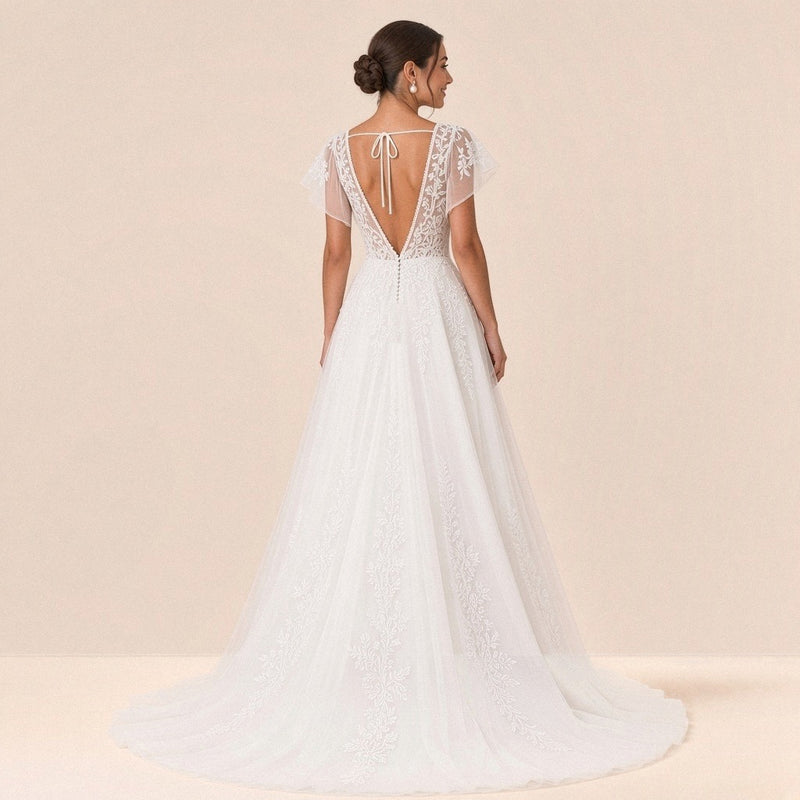Robe de mariée en dentelle vue de dos : dos ouvert en V, cordon noué et petite traîne en tulle