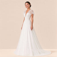 Robe de mariée en dentelle à mancherons en tulle et jupe trapèze, vue de trois quarts
