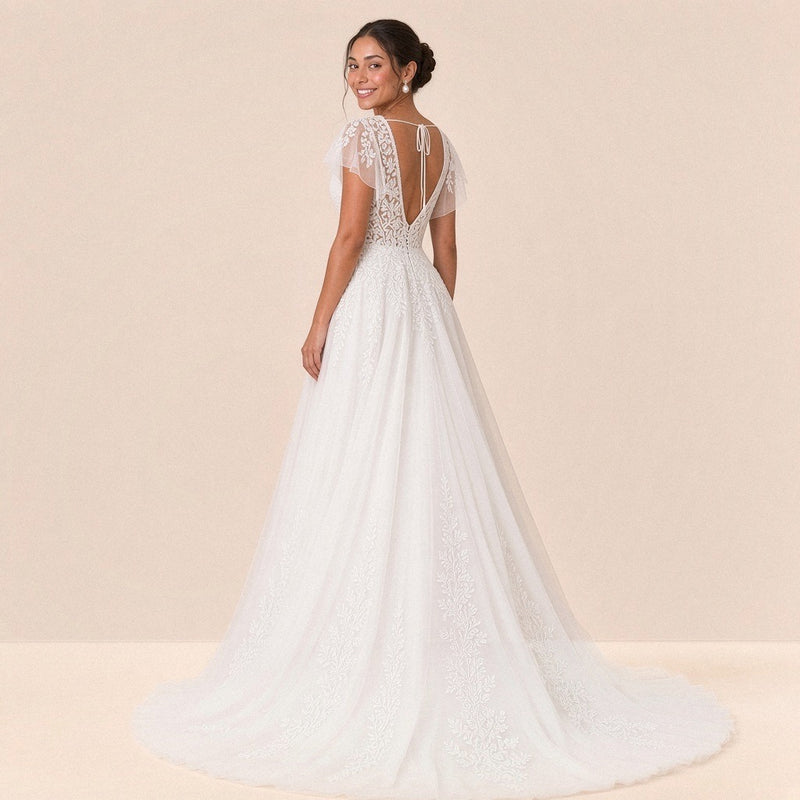 Robe de mariée en dentelle vue de trois quarts dos, petite traîne en tulle à appliques