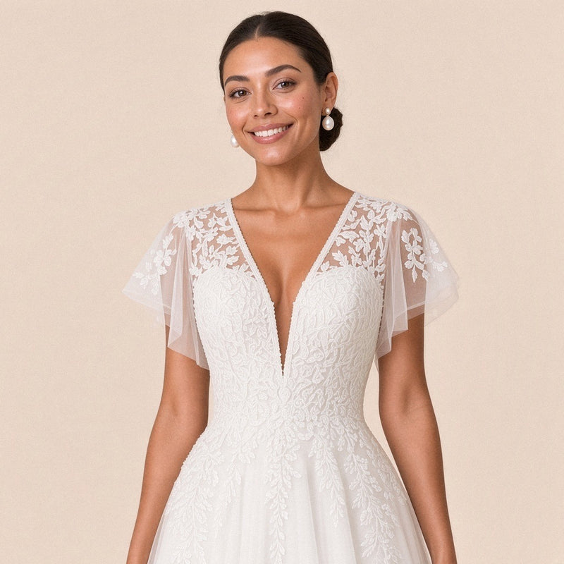 Gros plan du corsage en dentelle, décolleté en V perlé et mancherons en tulle brodé