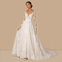 Robe de mariée évasée en dentelle et tulle, col V plongeant et manches longues transparentes, vue de face