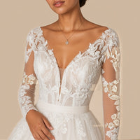 Gros plan du col V plongeant, du corsage en dentelle florale et de la ceinture en tulle froncé