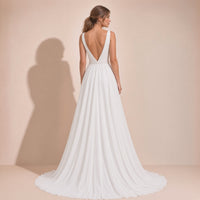 Vue de dos de la robe de mariée portée : dos en V, ceinture perlée et longue traîne