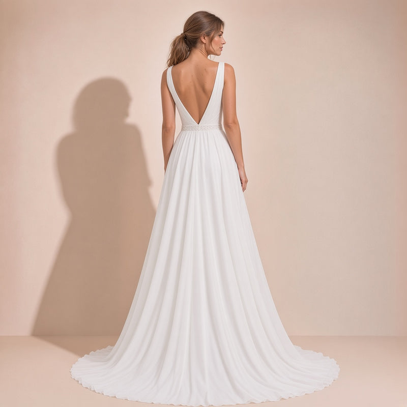 Vue de dos de la robe de mariée portée : dos en V, ceinture perlée et longue traîne