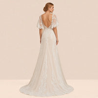 Robe de mariée en dentelle vue de dos, dos ouvert en arrondi et petite traîne