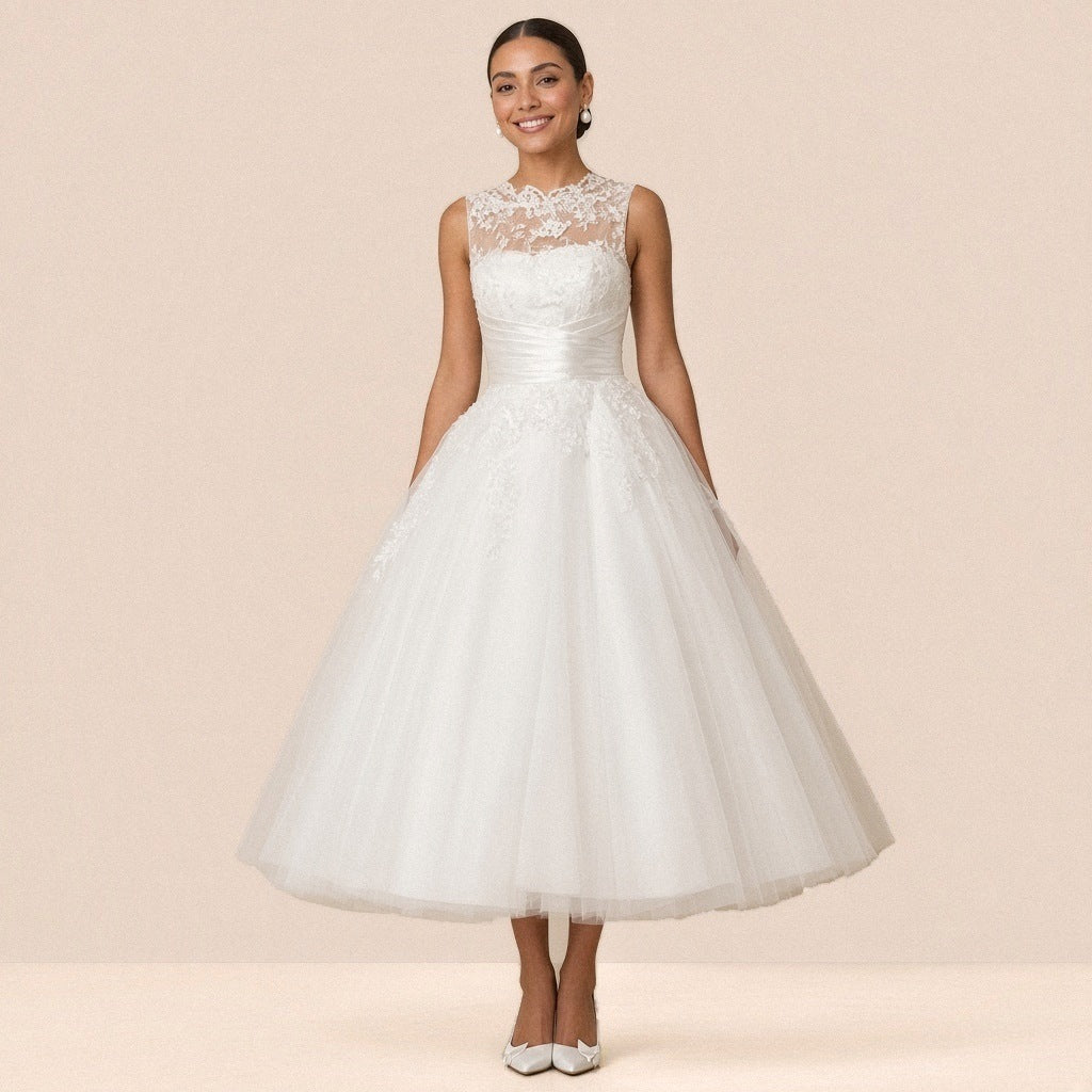 Robe de mariée blanche longueur cheville portée de face, col illusion en dentelle et jupe en tulle