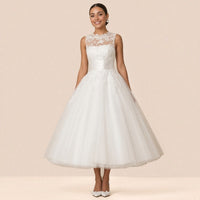 Robe de mariée blanche longueur cheville portée de face, col illusion en dentelle et jupe en tulle