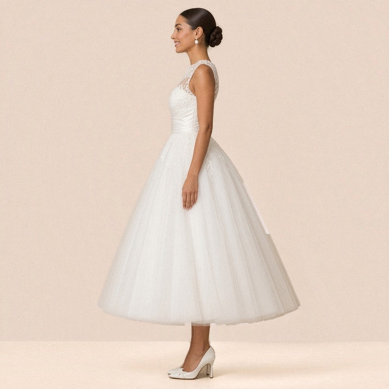 Robe de mariée en tulle de profil, col illusion et jupe volumineuse