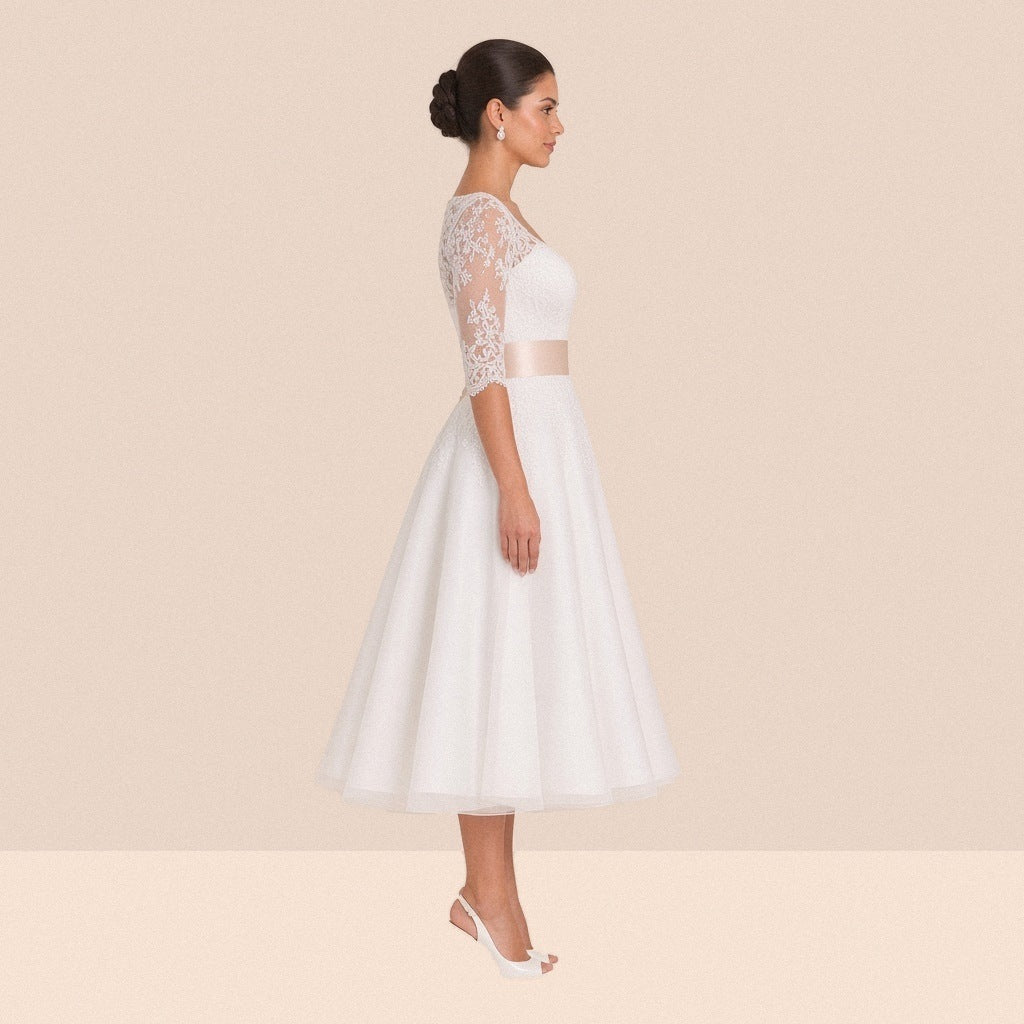 Robe de mariée en dentelle de profil, manche au coude et ceinture champagne