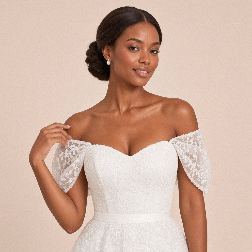 Robe de mariée mi-longue en dentelle à épaules dénudées – détail du buste et des manches drapées