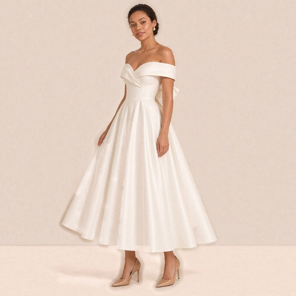 Femme de trois quarts dans la robe de mariée mi-longue en satin, jupe ample