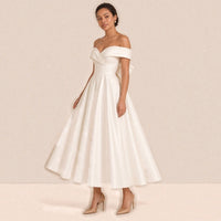 Femme de trois quarts dans la robe de mariée mi-longue en satin, jupe ample