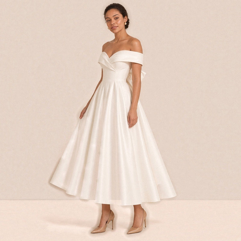 Femme de trois quarts dans la robe de mariée mi-longue en satin, jupe ample