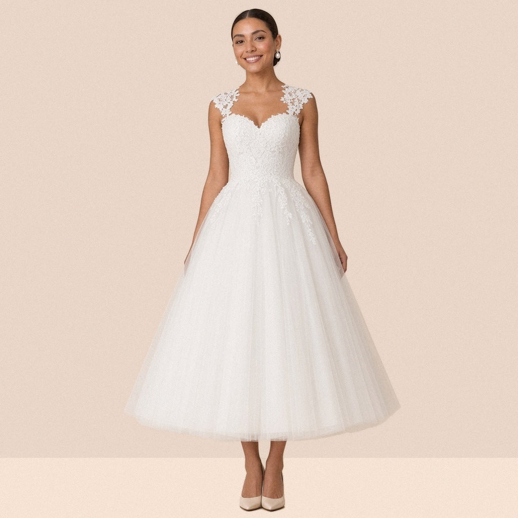Robe de mariée blanche mi-longue en tulle à décolleté cœur et mancherons en dentelle – vue de face, portée par une mannequin.