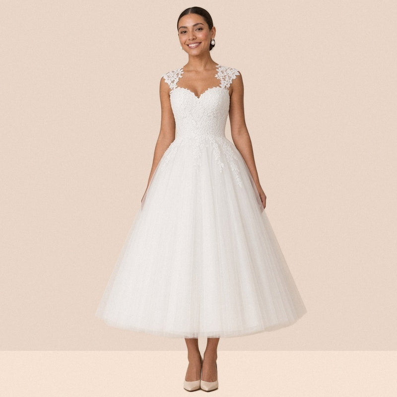 Robe de mariée blanche mi-longue en tulle à décolleté cœur et mancherons en dentelle – vue de face, portée par une mannequin.
