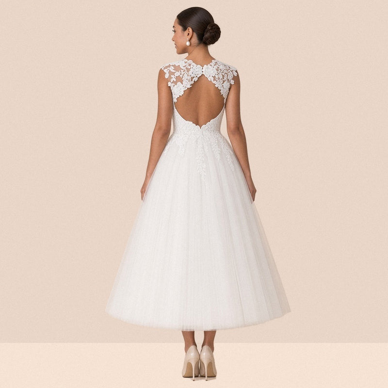 Robe de mariée blanche mi-longue – vue de dos : dos ouvert en goutte sous un empiècement de dentelle, jupe en tulle.