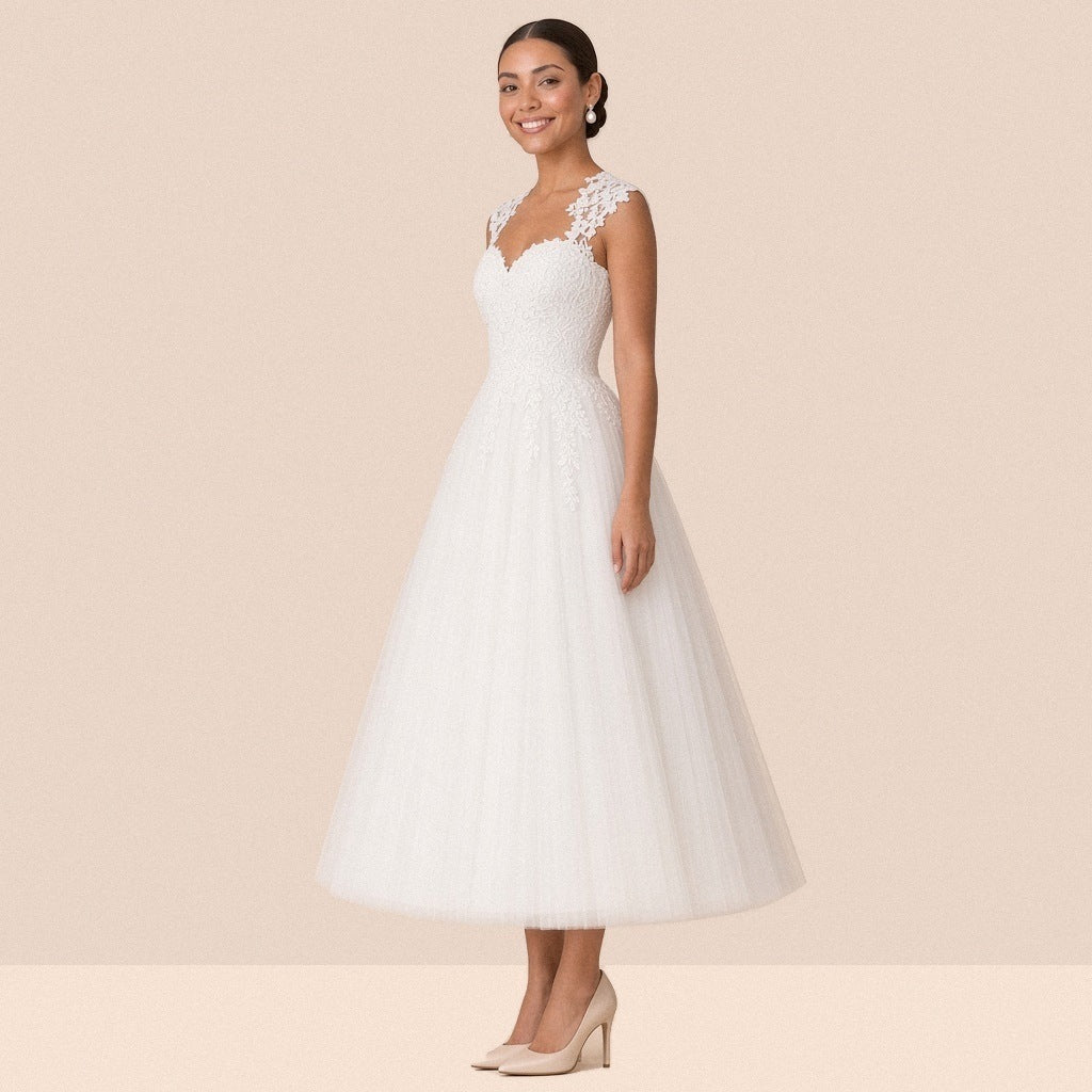 Robe de mariée blanche mi-longue en tulle à décolleté cœur et mancherons en dentelle – vue de trois quarts.