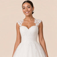 Robe de mariée blanche – détail du décolleté cœur, des mancherons et du corsage en dentelle florale.