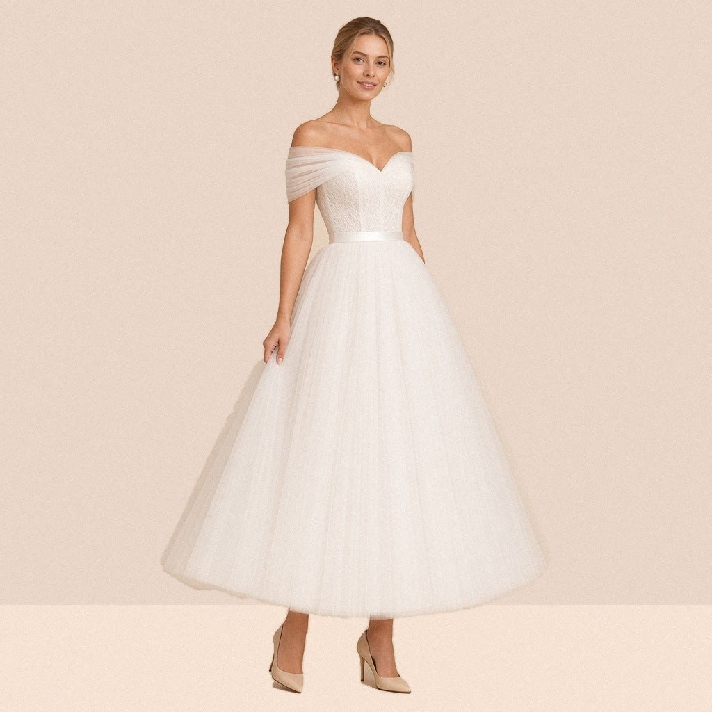 Robe de mariée ivoire mi-longue en tulle – vue de trois quarts, jupe ample au-dessus de la cheville.