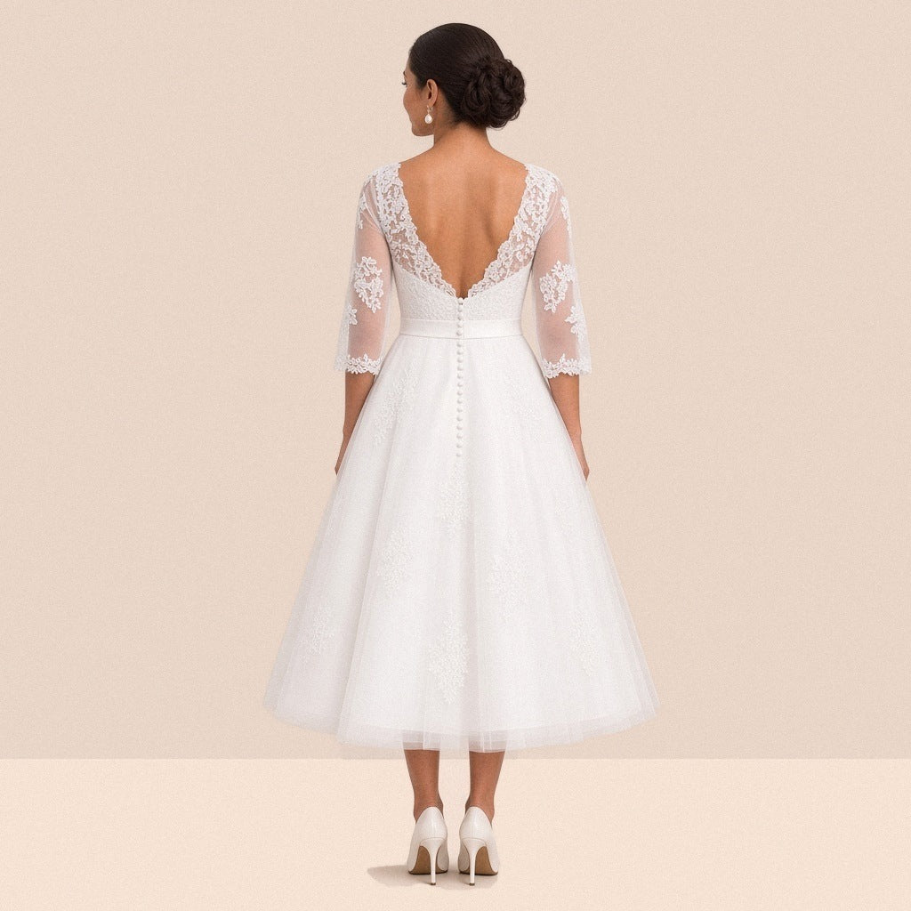 Robe de mariée en tulle vue de dos, dos en V bordé de dentelle et orné de petits boutons