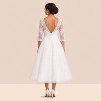 Robe de mariée en tulle vue de dos, dos en V bordé de dentelle et orné de petits boutons