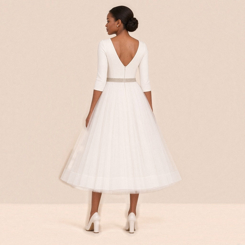 Femme de dos dans la robe de mariée mi-longue : dos en V zippé et taille perlée